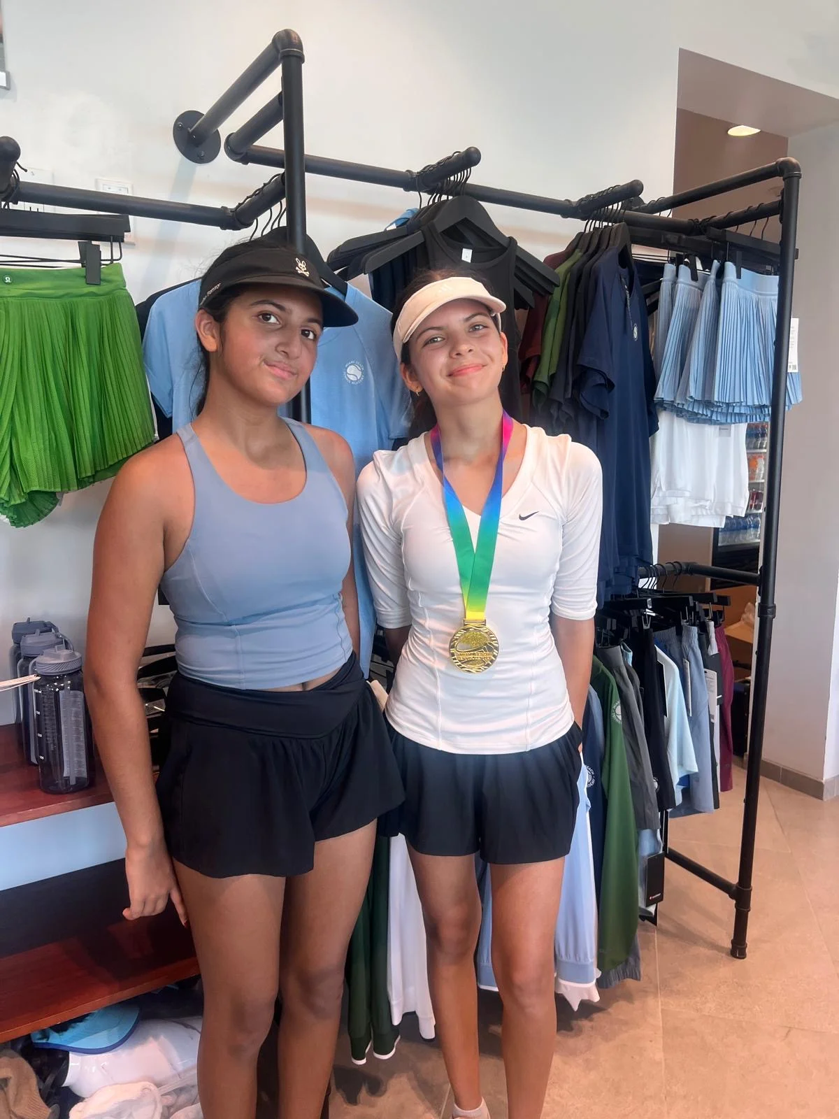 Two junior players celebrating a tournament with a medal